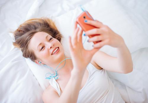 A girl takes a selfie in her bedroom.