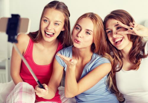 A group of friends take selfies to share on social media.